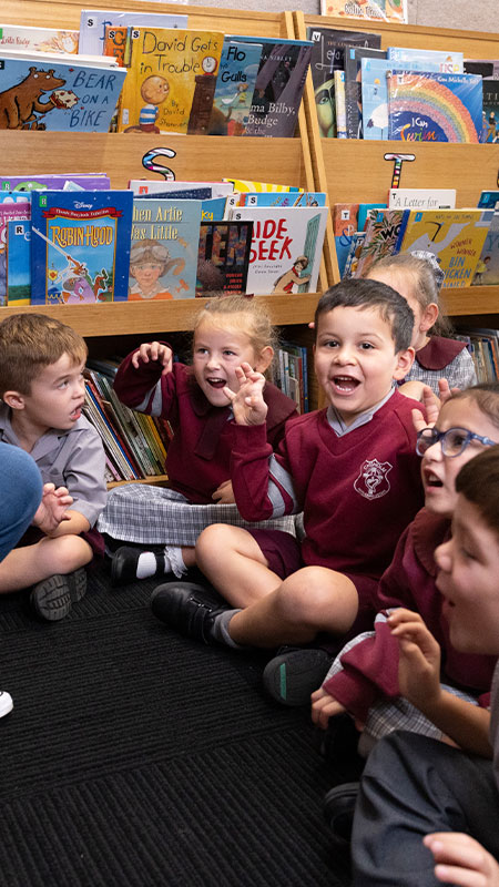 Chisholm Primary Bligh Park students sitting in the library while the teacher reads to them
