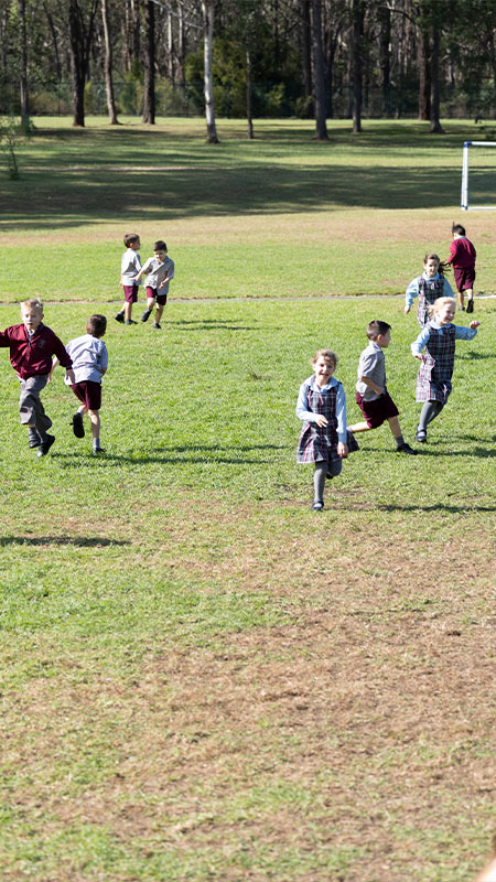 Chisholm Catholic Primary Bligh Park students playing on outdoor field