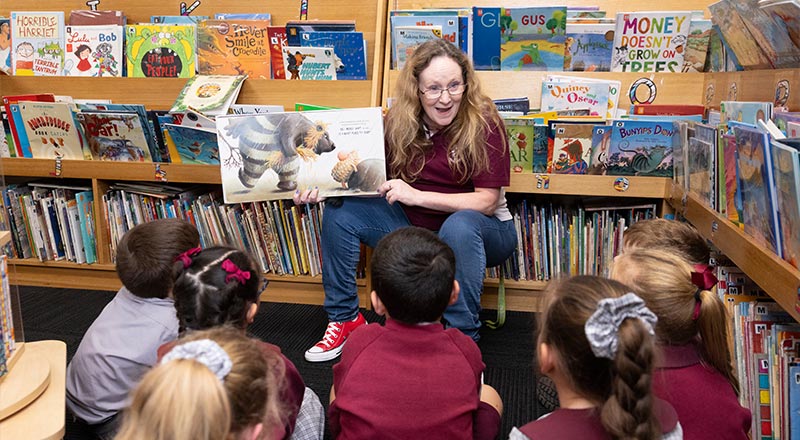 Teacher reading to students in school library