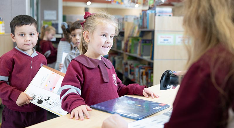 Student checking out book at library