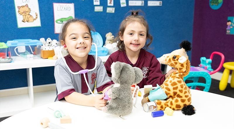 Student holding stethoscope to toy koala