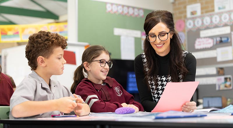 Teacher, two students, using laptops