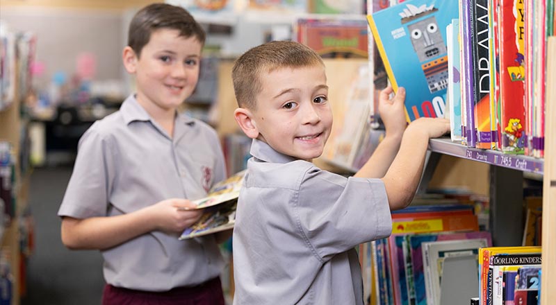 Student taking a book off the shelf
