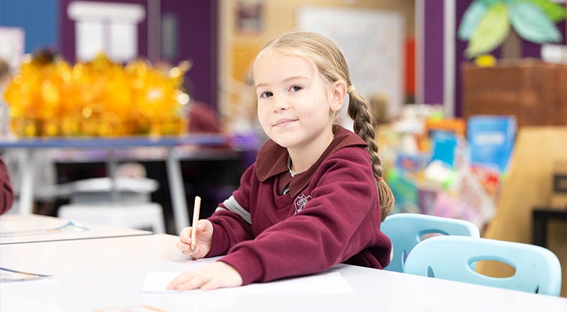 Child in class, writing on workpaper