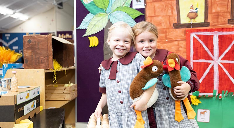 Two students playing with stuffed animals