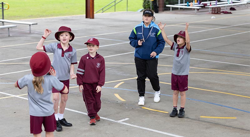 Four students and the PDHPE teaching on combo netball basketball court