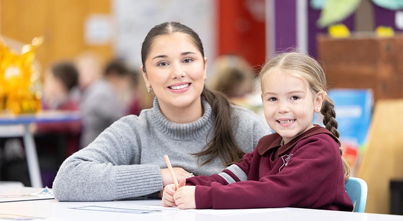 Teacher and student smiling at camera